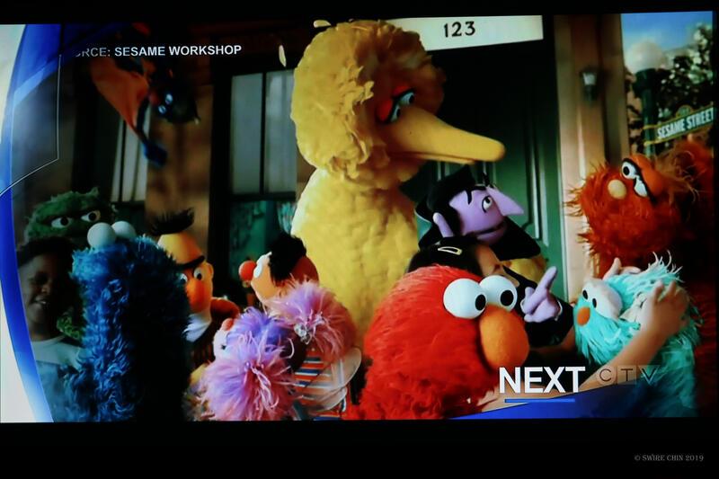 Sesame street characters interact on a TV screen
