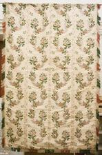 An off-white curtain embroidered with pink flowers, with fringe along the edges