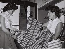 black and white photograph of two women holding a textile
