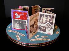 Star of David shaped paper sculpture with images and text on a circular base