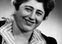 Gertrude Berg in costume as Molly Goldberg looking into camera and smiling 