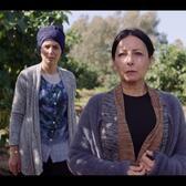 Still from Israeli ultra-Orthodox film Entangled: one woman (right) in focus and woman out of focus behind her standing surrounded by trees