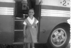 Ruth Behar as a child, standing in the open door of a bus