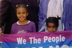 Marla Brettschneider and Family with Anti-Bush Banner, 2004