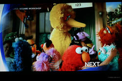 Sesame street characters interact on a TV screen
