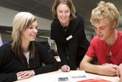 Stock image of a teacher working with students.