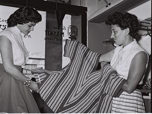 black and white photograph of two women holding a textile