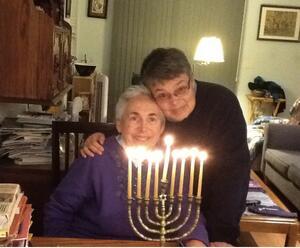 photograph of two women behind a Hanukkah menorah