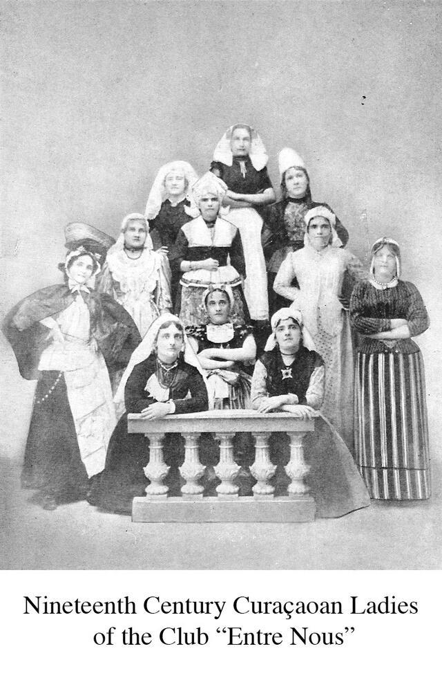 Eleven women in Curaçaon dresses and caps, posing for a group picture