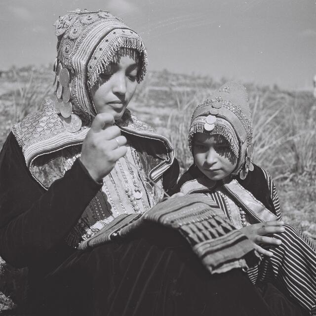 A Yemenite in traditional dress embroidering a garment, 1947.