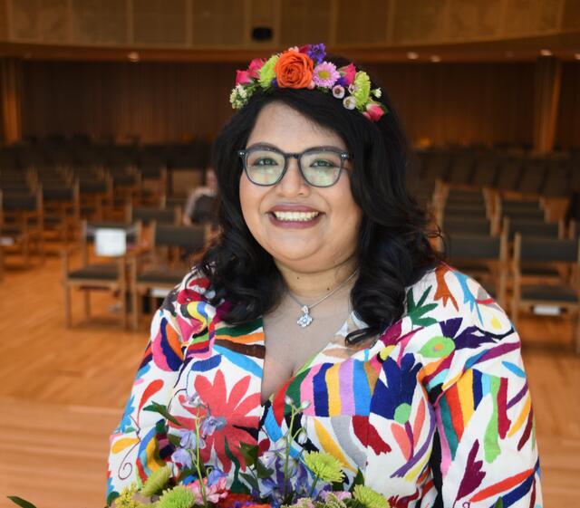 photograph of a woman with dark hearing wearing a flower crown and a colorful shirt