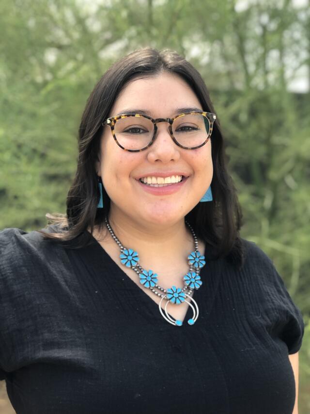 photograph of a woman with glasses and long dark hair wearing turquoise necklace