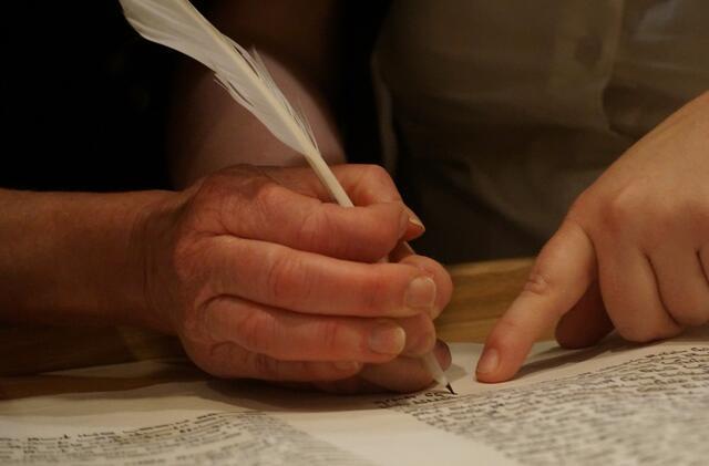 Hands scribing Torah