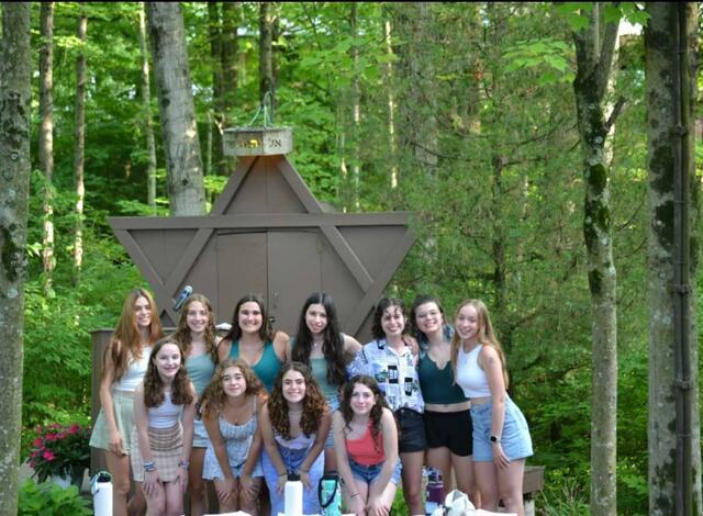 The author and her summer camp cabin posing for a photo