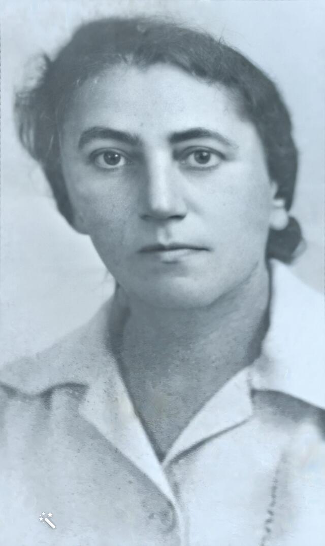 black and white photograph of a woman with dark hair pulled back, looking seriously at the camera